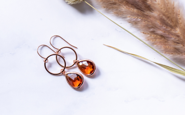 Filigrane Ohrringe in Rosegold mit Glassteinen in leuchtenden Farben.